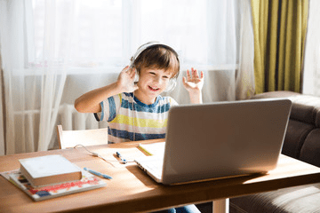 Boy performing online school work and making raise the roof gesture